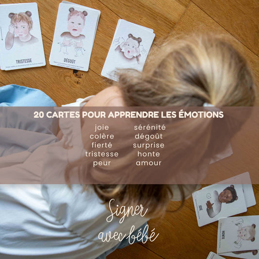 Cartes bébé signe pour apprendre les émotions, étalées et manipulées par un enfant