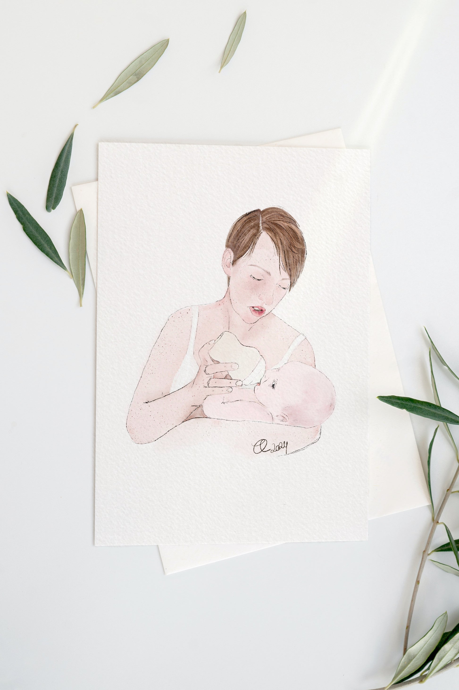 Portrait d'une maman donnant de biberon à son bébé présenté sur fond blanc avec des feuilles d'olivier