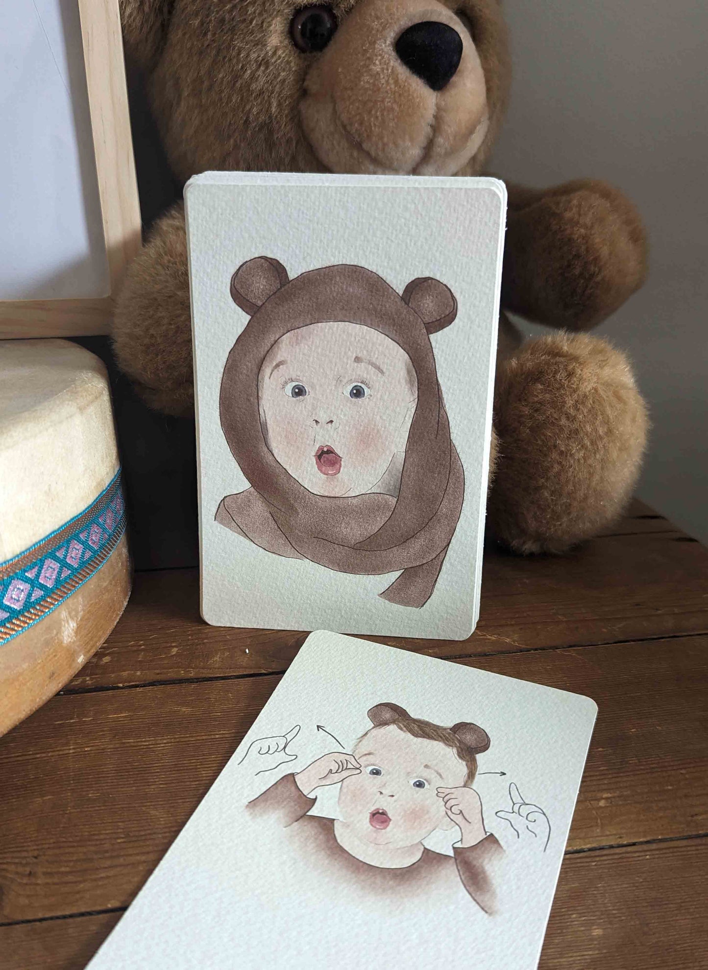 Cartes Signer avec Bébé les Émotions, émotion surprise présentée devant un ourson brun
