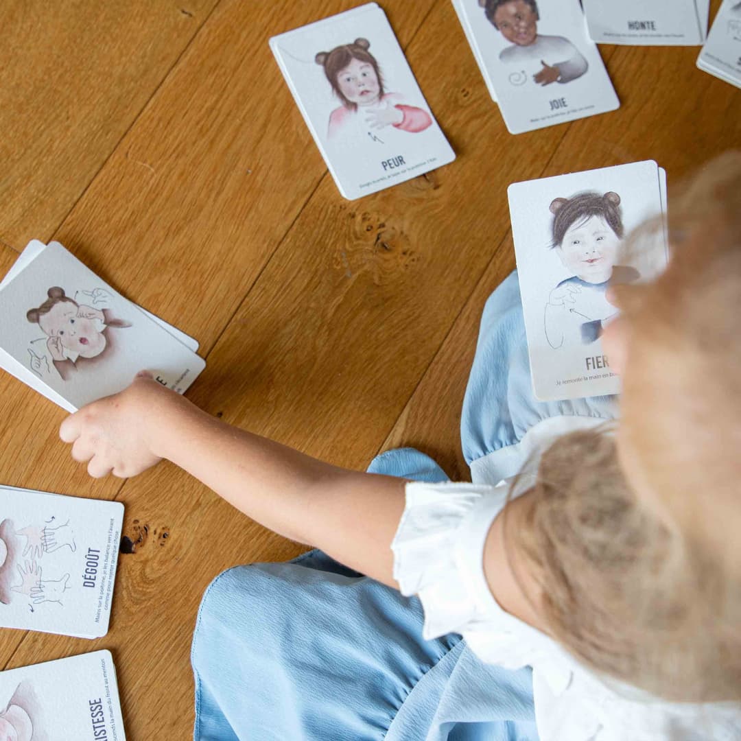 Enfant attrapant une carte bébé signe illustrant une émotion
